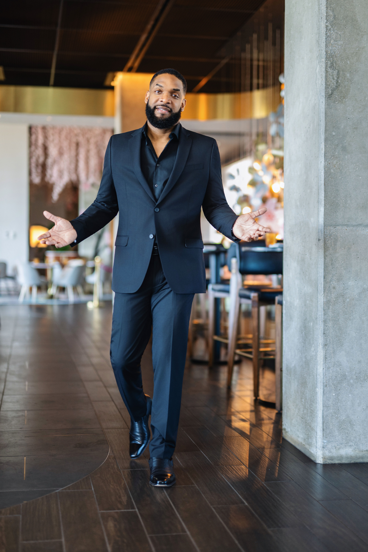 Jay Cameron in a dark suit walking toward the camera